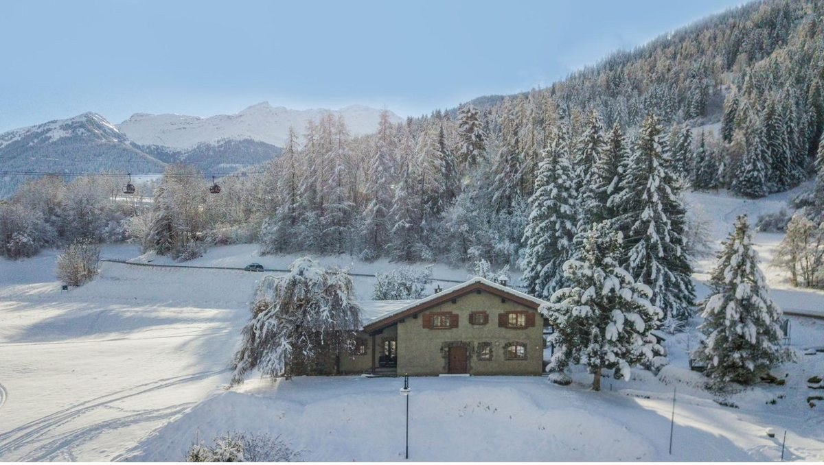 Snow-covered Val de Bagnes with chalets and forest
